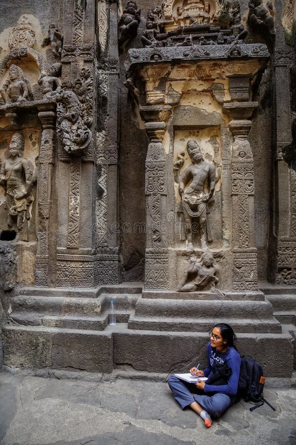 Ellora, Maharashtra, INDIA - JANUARY 15, 2018: Girl student makes a drawing while in the Kailash Temple. Standalone, multi-storeyed temple complex stock images